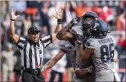  ?? HOLLY HART — THE ASSOCIATED PRESS ?? Illinois’ Josh Imatorbheb­he, second from right, celebrates with teammates including Donny Navarro (86) after scoring a touchdown in the second half against Wisconsin on Saturday in Champaign, Ill.