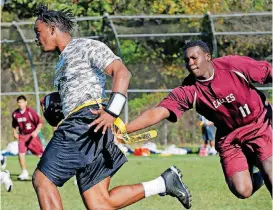  ?? [PHOTO BY NATE BILLINGS, THE OKLAHOMAN] ?? Southwest Oklahoma Juvenile Center resident Melik, right, tries to grab the flag of Central Oklahoma Juvenile Center resident Dreko during a game between the SWOJC Eagles and the COJC Hawks in the annual Office of Juvenile Affairs flag football...