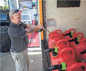  ?? AMANDA INSCORE/USA TODAY NETWORK ?? Mike Emmerling fills gasoline cans ahead of Tropical Storm Idalia at a Wawa gas station Monday in Fort Myers on Florida’s west coast. Forecaster­s expected the system to rapidly intensify into a hurricane.