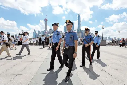  ??  ?? Two Italian police officers join their local counterpar­ts yesterday to patrol the Bund area. This is the second time Italian police officers are patrolling Shanghai’s streets. — Jiang Xiaowei