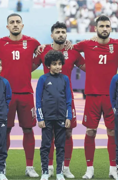  ?? ?? ↑ Iran players fall silent during the pre-match national anthem. Right, Mason Mount celebrates with the star of the show – England’s No 22 Jude Bellingham