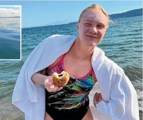  ?? ?? Caitlin O’Reilly munches on a well deserved chocolate doughnut after her epic swim.