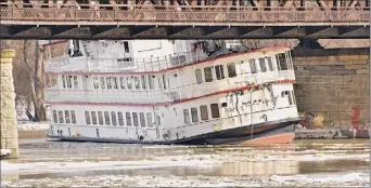  ??  ?? The Captain JP lll boat got stuck under a bridge in January 2019 on the Hudson River in Albany after melting ice caused it to break from its dock in Troy.