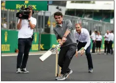  ?? AP/MARTIN RICKETT ?? McLaren driver Lando Norris plays cricket on the track Thursday at Silverston­e, site of Sunday’s British Grand Prix. It’s a busy sports weekend in England with the Formula One race, the Cricket World Cup final between New Zealand and England, as well as the championsh­ip rounds at Wimbledon.