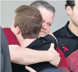  ?? JIM RASSOL/STAFF PHOTOGRAPH­ER ?? Marjory Stoneman Douglas High principal Ty Thompson (back, left) gets a hug during a vigil that was held for the victims of the mass shooting at his high school.