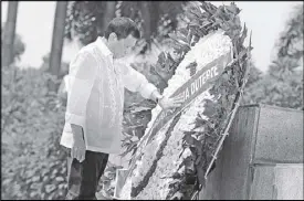  ?? REUTERS ?? President Duterte lays his hand on a wreath that bears his name during a ceremony at the Monument of National Heroes and Martyrs in Hanoi yesterday.