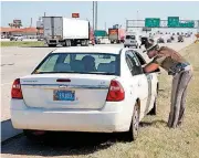  ?? [PHOTO BY STEVE GOOCH, THE OKLAHOMAN] ?? Trooper Chantz Jackson with Oklahoma Highway Patrol’s Troop A talks to a driver during a traffic stop on Interstate 40 in Oklahoma City.