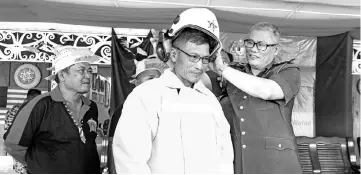  ??  ?? Hamdan (right) dressing a member of the Voluntary Firefighti­ng Team in a fire jacket and safety helmet at Uma Daro, Sungai Asap, Madang Lidam during his visit to Belaga yesterday. - Bernama photo