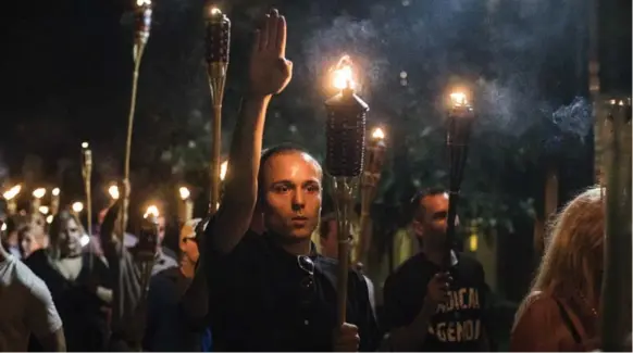  ?? EDU BAYER/THE NEW YORK TIMES ?? At a planned rally in Charlottes­ville, Va., last weekend, a group carrying Tiki torches chanted “blood and soil,” a 19th-century German nationalis­t term used by the Nazis.