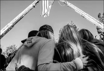  ?? APU GOMES/GETTY-AFP ?? Friends hug outside the Los Robles Medical Center on Thursday in Thousands Oaks, Calif., as they pay tribute to Ventura Country sheriff Sgt. Ron Helus, who was killed in a shooting at Borderline Bar the night before.