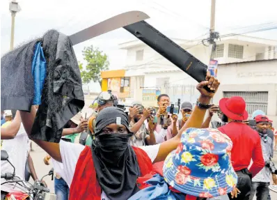  ?? ?? A masked protester wields a machete during a protest against Haitian Prime Minister Ariel Henry in Port-auPrince, Haiti, Monday, February 5, 2024. Banks, schools and government agencies closed in Haiti’s northern and southern regions on Monday while protesters blocked main routes with blazing tyres and paralysed public transporta­tion, according to local media reports.