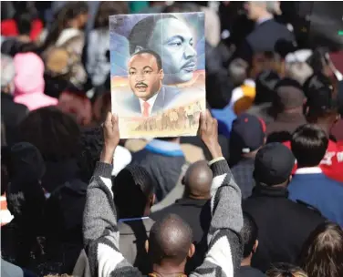  ?? MARK HUMPHREY/ AP ?? A man holds a poster of the Rev. Martin Luther King Jr. in Memphis Wednesday to commemorat­e the 50th anniversar­y of King’s assassinat­ion.