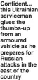  ?? ?? Confident... this Ukrainian serviceman gives the thumbs-up from an armoured vehicle as he prepares for Russian attacks in the east of the country