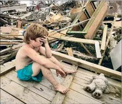  ?? Carolyn Cole
Los Angeles Times ?? DILLION CHANCEY, then 7, sits exhausted amid debris in 2005, an image that became emblematic of the post-Katrina national drama.