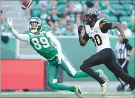  ?? The Canadian Press ?? Saskatchew­an Roughrider­s’ Duron Carter (89) attempts a one-handed intercepti­on against Hamilton Tiger-Cats receiver Terrence Toliver during first-half CFL action at Mosaic Stadium in Regina on Thursday night.