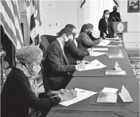  ?? AMYDAVIS/BALTIMORE SUN ?? Thelma T. Daley, front, and other electors sign the Certificat­e of Vote during the 59th meeting of the Maryland Electoral College at the State House.