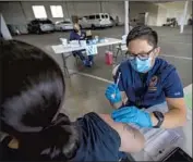  ?? Francine Orr Los Angeles Times ?? REGISTERED NURSE Justine Bertulano, right, gives Yolanda Estrada-Saporito of Garden Grove her second dose of the Moderna vaccine in Gardena.