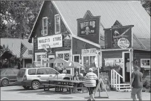  ?? AP/MARK THIESSEN ?? Tourists walk along historic Main Street in Talkeetna, Alaska, in mid-July.