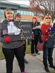  ?? SUSAN SERBIN – DIGITAL FIRST MEDIA ?? Marie Trumbull, left, and Jeanne Mann are among four dozen protesters singing “carols” adapted for tax bill protest outside the Springfiel­d office of U.S. Rep. Pat Meehan.