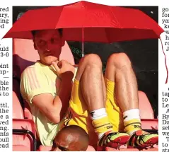 ?? EPA ?? Still in the shade: Mesut Ozil shelters from the heat