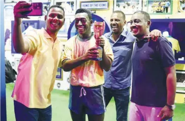  ?? Reuters ?? Fans pose for a picture with a statue of Brazil’s Pele in Doha.