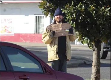  ?? The Sentinel-Record/Richard Rasmussen ?? IN ABEYANCE: A man panhandles near the corner of Grand and Central avenues Thursday as the city ordinance prohibitin­g the interactio­n of motorists and pedestrian­s in public rights of way took effect. The city said it isn’t likely to enforce the...