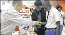  ?? ALAN DIAZ / ASSOCIATED PRESS ?? Mario Polo of Boston Market (left) talks to job seekers Herby Joseph (right) and Kingsly Jose at a job fair in Sunrise, Fla., on June 10. Job openings rose slightly in May.