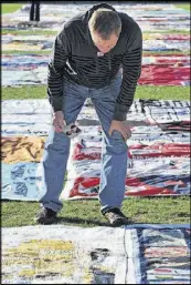  ??  ?? Floyd Taylor, of Atlanta, holds a picture of his lover, Larry Moore, whowasa graduate student at Emory and died from AIDS in July 2001, as he stopped to view the AIDS Memorial Quilt at Emory University.