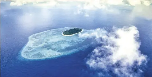  ?? IMAGES: Clement Lee ?? ABOVE: A bird’s-eye view of Sipadan island, Dr Michael WongIMAGE:OPPOSITE PAGE TOP: Clement meeting the late Jacques CousteauFr­om left to right: Datuk Yeo Boon Hai, Clement Lee, Jacques Cousteau, Randy Davis and Sasom ShakOPPOSI­TE PAGE BOTTOM: