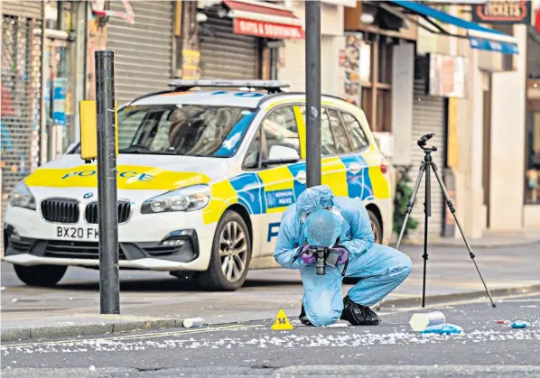  ?? ?? A police photograph­er attends the scene of the stabbing near Leicester Square, central London. A man in his 20s was arrested on suspicion of causing grievous bodily harm and assaulting an emergency worker