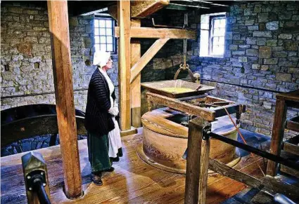  ?? Gretchen McKay photos / Pittsburgh Post-Gazette ?? A visit to George Washington’s reconstruc­ted gristmill at Mount Vernon includes demonstrat­ions by millers in early-American attire.