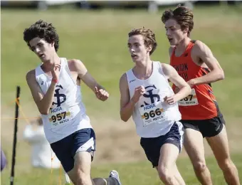  ?? PAUL cONNORS / BOSTON HERALD ?? DOMINANT DAY: St. John’s Prep’s Nathan Lopez, left, leads teammate Charlie Title, center, and Newton North’s Tyler Tubman through a turn during the MSTCA Bay State Invitation­al on Saturday in Wrentham.