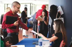  ?? Associated Press ?? ■ An employee of Aldi, right, takes an applicatio­n from a job applicant on Jan. 30 at a JobNewsUSA job fair in Miami Lakes, Fla. On Friday, U.S. government issued the March jobs report.