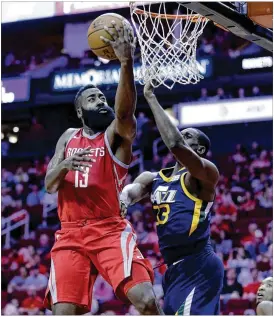  ?? MICHAEL WYKE / ASSOCIATED PRESS ?? Rockets guard James Harden lays up a shot past Utah Jazz center Ekpe Udoh in the first half of their game Sunday. Harden had 30 points by halftime.