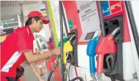  ?? — Reuters ?? A service station worker tidies up the gas hoses at a petrol station in Jakarta, Indonesia.