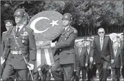  ?? AP ?? President Recep Tayyip Erdogan follows wreath carriers Thursday as he and other Turkish officials pay tribute to modern Turkey’s founder Mustafa Kemal Ataturk at an Ankara mausoleum on Victory Day. Victory Day marks the Turks’ war for independen­ce triumph against Greek forces in the 1922 Battle of Dumlupinar.