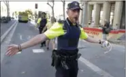  ?? MANU FERNANDEZ — THE ASSOCIATED PRESS ?? A police officer cordons off a street in Barcelona, Spain, Thursday.