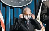  ?? MICAHEL A. MCCOY/THE NEW YORK TIMES ?? Dr. Anthony Fauci puts on a face mask during a coronaviru­s task force briefing last month in Washington.