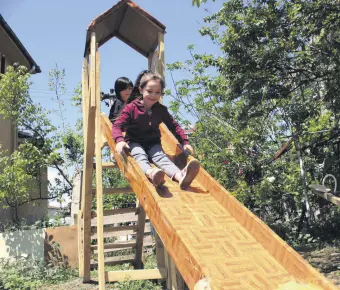  ??  ?? Children slide down a slide in the backyard of their house, in Kocaeli, northweste­rn Turkey, May 11, 2020.