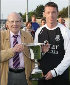  ??  ?? Jim McLaughlin presents the McLaughlin Cup to PJ Dowling, captain of Newtown.