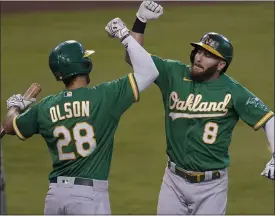  ?? ASSOCIATED PRESS FILE PHOTO ?? Oakland Athletics’ Robbie Grossman, right, celebrates his solo home run with teammate Matt Olson in a 2020 game. Grossman has inked a two-year deal with the Detroit Tigers.