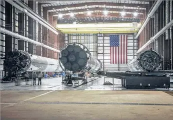  ?? Photograph­s by SpaceX ?? THREE previously used SpaceX rocket boosters, above, sit in a hangar at Kennedy Space Center in Florida. Top left, a Falcon 9 rocket lifts off from the space center in April 2016. Top right, the first-stage booster lands on a drone ship for the first time. The booster will be used in a satellite launch Thursday.