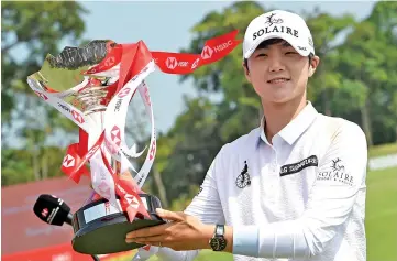  ?? - AFP photo ?? Park Sung-hyun of South Korea poses with the winner’s trophy after the final round of the HSBC Women’s World Championsh­ip at the Sentosa Golf Club in Singapore .