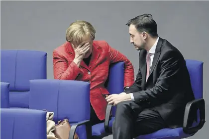  ?? EFE / CLEMENS BILAN ?? Angela Merkel charla con el líder de las juventudes de la CDU, Paul Ziemiak, ayer en el Bundestag.