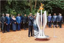  ?? Brian Inganga/Associated Press ?? Rwandan President Paul Kagame lights a memorial flame Sunday during a ceremony marking the Rwandan genocide.