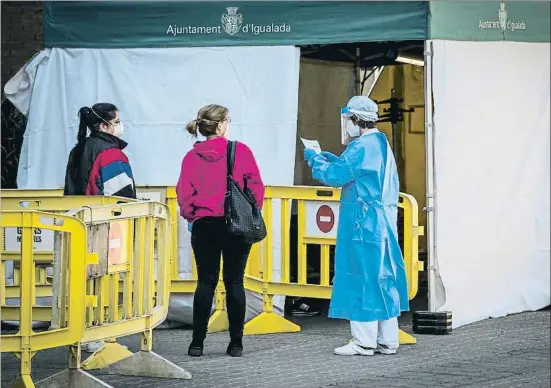  ?? LLIBERT TEIXIDÓ ?? Una trabajador­a sanitaria atendiendo a dos ciudadanas, ayer en Igualada