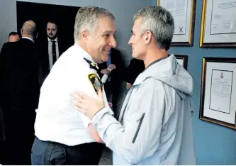  ?? JASON BAIN/EXAMINER ?? Peterborou­gh Police Service Chief Murray Rodd is congratula­ted by Peterborou­gh Police Associatio­n president Jeff Chartier after announcing his June 30 retirement at police headquarte­rs on Water St. on Tuesday afternoon.