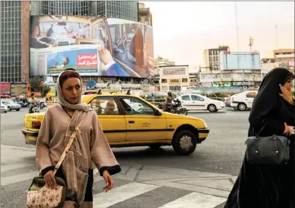  ?? PICTURE: BLOOMBERG ?? An Iranian woman crosses an intersecti­on near the Grand Bazaar in Tehran. Citizens are feeling the bite of US sanctions on Iran.