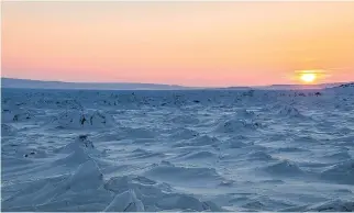  ??  ?? FEB. 2 8, 2 0 1 5 Sunset seen from the Co-op side of the village of Kangirsuk at 5 p.m. Kangirsuk is divided into two neighbourh­oods, named after its two general stores, the Co-op and the Western. Some people use this frozen part of the bay to cross...