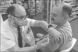  ?? IRFAN KHAN/LOS ANGELES TIMES ?? Pharmacist Aaron Sun administer­s a COVID-19 vaccine to Jimmy Smagula at a CVS in the Eagle Rock neighborho­od of Los Angeles.